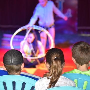 Drei Kinder sehen eine Zirkusvorstellung